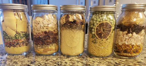 Fresh herbs and dried vegetables in the glass jars
